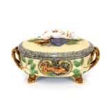 A Minton Majolica game pie dish and cover, decorated gun dog and shooting apparel to the lid, the