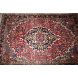 A Middle Eastern floral pattern rug, having lozenge decoration within multi floral borders on a