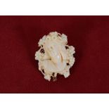 A 19th Century carved ivory brooch, depicting head and shoulders profile study of a lady within vine