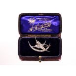 A white metal and diamond set brooch, in the form of a swallow and crescent