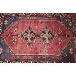 A Middle Eastern rug, of Caucasian design predominately red and blue ground, 152cm x 111cm