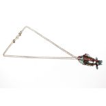 A white metal and enamel decorated articulated fish pendant, hung to a fine link chain
