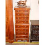 A reproduction yew wood miniature tall boy chest, fitted eight drawers raised on a shaped apron