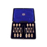 A cased set of twelve silver Trefid end Rat Tail teaspoons, and matching sugar tongs in fitted