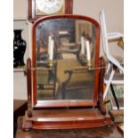 A Victorian mahogany swing toilet mirror, the arched plate supported on scrolled arms on a