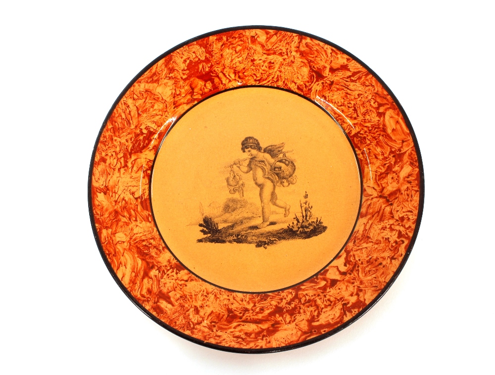 A 19th Century nursery plate, having cherub decoration within an orange sponged border, 18cm