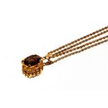 A yellow metal pendant, set with smoky quartz and hung to a 9ct gold rope twist chain