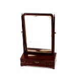 A Georgian mahogany swing toilet mirror, the shaped plate with gilt slip, raised on a three drawer