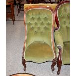 A Victorian rosewood framed spoon back nursing chair, upholstered in green buttoned Dralon, raised