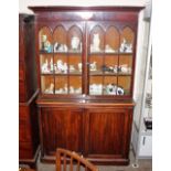 A 19th Century mahogany bookcase, the upper shelves enclosed by a pair of glazed arch panelled