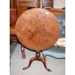 A Georgian mahogany circular snap top tea table, raised on a turned baluster column and tripod base,