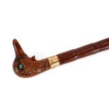 An unusual Edwardian walking cane, the carved handle in the form of a ducks head with glass eyes and