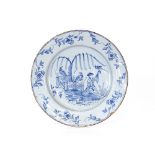 An 18th Century Delftware charger, decorated trees and fence, 36cm dia.; an 18th Century delft plate