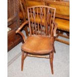 A 19th Century elm stick back elbow chair, the shaped seat raised on turned supports united by an