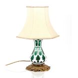 An overlaid green glass baluster table lamp, on gilded base, 33cm high (without shade)
