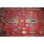 A Middle Eastern rug, of multi floral pattern on predominately red and blue ground within stylised