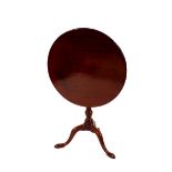 A Georgian mahogany circular snap top tea table, raised on a ring turned baluster column and