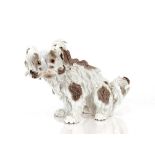 A Dresden porcelain figure, of a seated dog, 31cm long x 21cm high