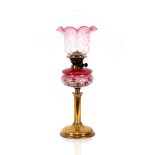 A Victorian brass oil lamp, having floral enamelled pink glass reservoir and tinted shade, 65cm