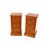 A pair of burr oak and rosewood crossbanded bedside chests, fitted pull out slides and three