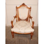 A Victorian walnut armchair, with carved foliate decoration and pale foliate stamped brocade