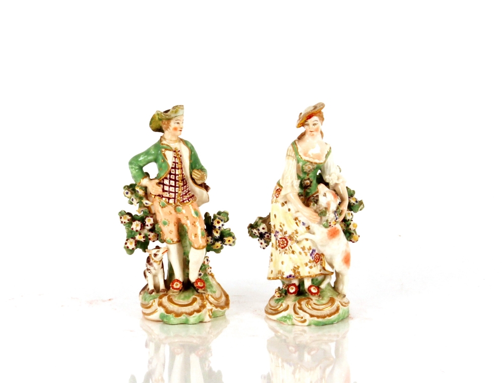 A pair of 19th Century porcelain figures, depicting shepherd and shepherdess, with floral