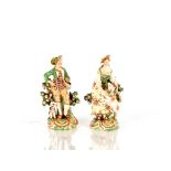 A pair of 19th Century porcelain figures, depicting shepherd and shepherdess, with floral