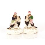 A pair of Victorian Staffordshire spill holders, in the form of a maid and youth with oversized