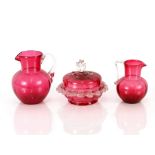 Two cranberry baluster milk jugs, having clear glass handles; and a cranberry and clear glass