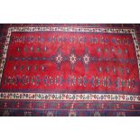 A Middle Eastern small carpet, having profuse floral design on predominately red and blue ground,