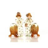 A pair of Victorian bisque ware posy holders, in the form of two girls with floral encrusted