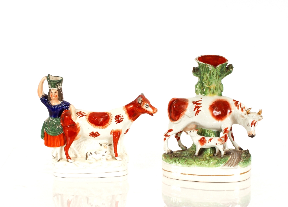 A Victorian Staffordshire spill holder, in the form of cow and suckling calf, 29cm high, 22cm