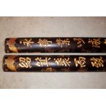 A pair of Chinese lacquered and gilt decorative columns, decorated symbols and foliage