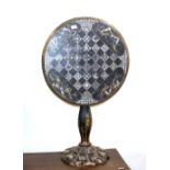 A Victorian papier maché and mother of pearl decorated tilt top chess table, raised on baluster