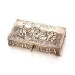 A continental silver trinket box, profusely decorated with Bacchanalian cherubs, locking hinged