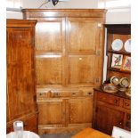 A large bespoke oak free standing double corner cupboard, the upper shelves enclosed by a pair of