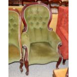 A Victorian mahogany framed spoon back armchair, upholstered in green buttoned Dralon, raised on