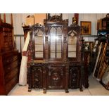 An antique carved oak dresser, of breakfront form, the upper section profusely decorated with