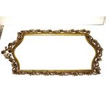 An ornate brass wall mirror, with foliate head decoration, bevelled plate, 90cm x 57cm in extremes