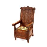 An unusual antique carved oak elbow chair, decorated profuse foliate scrolls around a central
