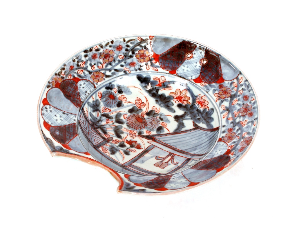 A 18th Century Japanese porcelain barbers bowl, under glazed blue and iron red decoration with