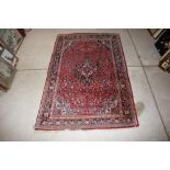 A Middle Eastern floral pattern rug, having profuse floral decoration on a red and blue ground,