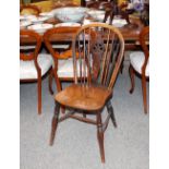 A set of four elm seated stick and wheel back dining chairs