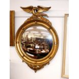 A Regency style gilt convex wall mirror, with eagle surmount and ball decoration above acanthus