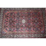 A Middle Eastern rug, of multi floral stylised pattern on predominately red ground, 140cm x 98cm