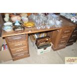 An oak pedestal desk fitted eight drawers