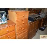 A pair of stripped pine three drawer bedside chest