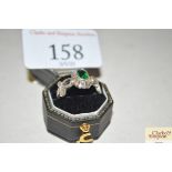 A silver and green stone set ring