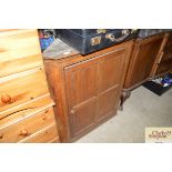 An antique oak corner cupboard