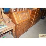 An oak linen fold decorated bureau